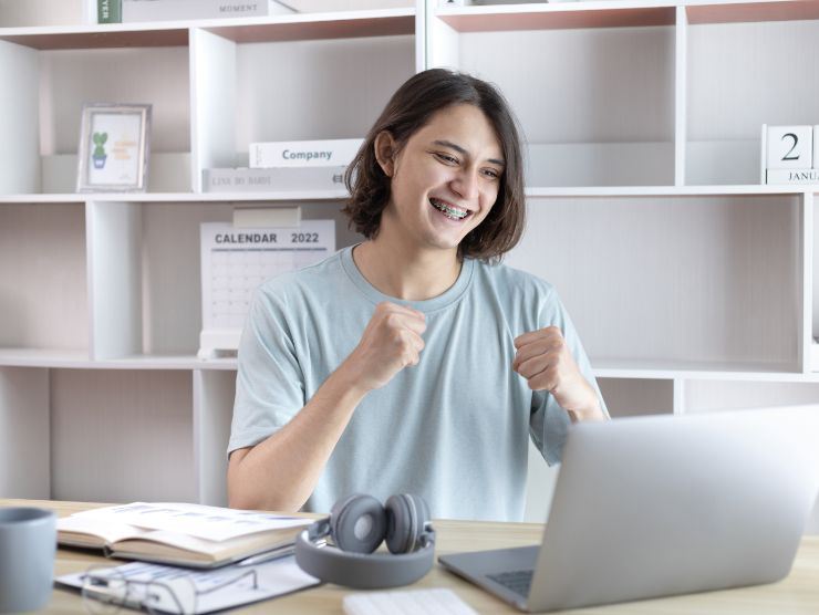 giovane che esulta davanti al pc